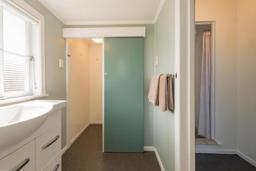 a bathroom with a sink and a mirror at Averill Court Motel in Paihia