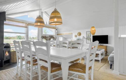 a white dining room with a white table and chairs at Holiday Home Ballesvej in Øster Assels