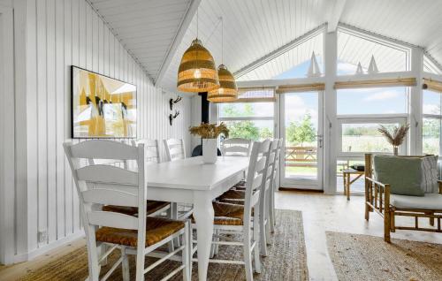 a white dining room with a white table and chairs at Holiday Home Ballesvej in Øster Assels