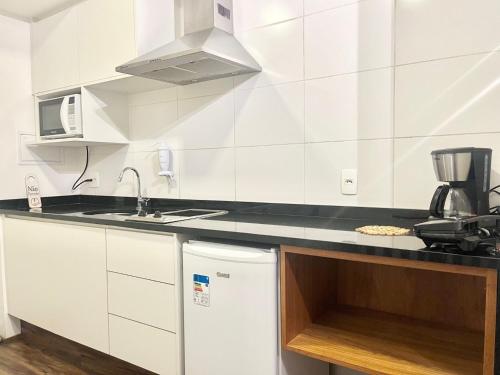 a white kitchen with a sink and a dishwasher at Flat WiseSP - Expo Anhembi in Sao Paulo