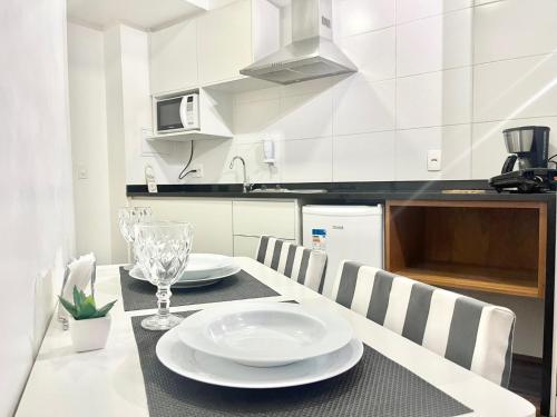 a kitchen with a table with plates and glasses on it at Flat WiseSP - Expo Anhembi in Sao Paulo