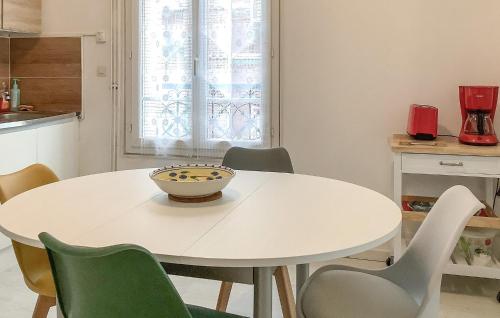 - une table blanche avec des chaises et un bol dans l'établissement Cozy Apartment In Mers-Les-Bains, à Mers-les-Bains