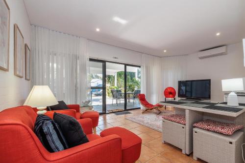 a living room with a red couch and a television at Corlette Retreat in Corlette