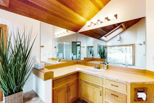 ein Badezimmer mit Waschbecken und großem Spiegel in der Unterkunft Meadow's Edge in Black Butte Ranch