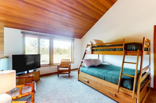 1 Schlafzimmer mit Etagenbetten und einem Flachbild-TV in der Unterkunft Meadow's Edge in Black Butte Ranch