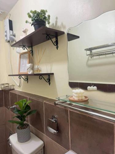 a bathroom with a mirror and a toilet and a sink at Arezzo Place Davao in Lanang