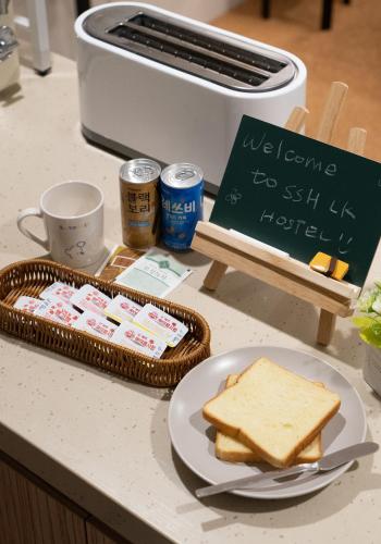 Ein Tisch mit einem Teller Toast und einem Teller Brot in der Unterkunft SSH LK Hostel in Seoul