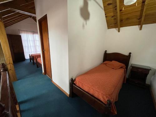 1 dormitorio con 1 cama en una habitación con alfombra azul en El Horreo Apart en Villa Gesell