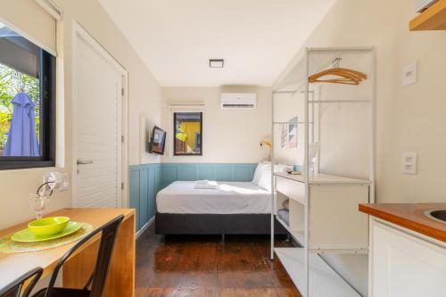 um pequeno quarto com uma cama e uma secretária em Coração da Lagoa da Conceição-Cozinha Completa-AC em Florianópolis