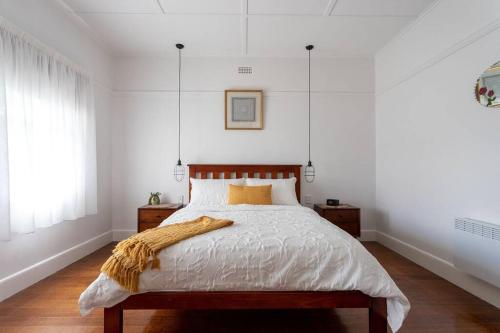 une chambre avec un lit avec une couverture dessus dans l'établissement Victoria Cottage, à Ulverstone
