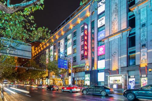 a busy city street with cars parked in front of buildings at Mason Hotel in Shanghai