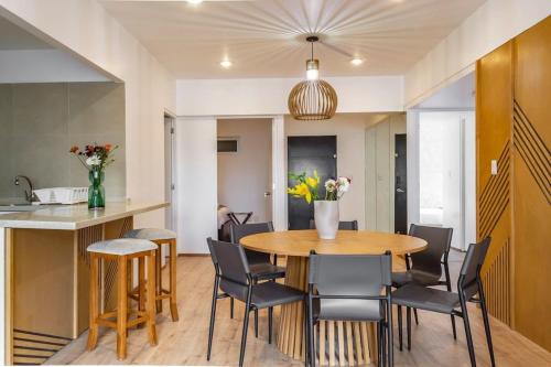 a kitchen and dining room with a wooden table and chairs at Cozy & Stylish apartmen @ New Polanco 3bed/2.5bath in Mexico City