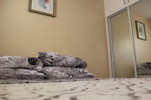 a bedroom with a bed with a pillow and a mirror at Mi Casa de San Remo l WIFI l NETFLIX l PARKING in Basak
