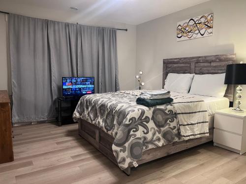 a bedroom with a bed and a television in it at Modern Vac Home, private Hot tub, close to airport in Moncton