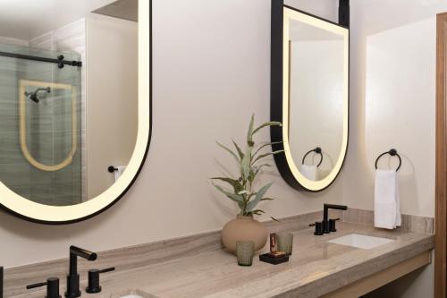 a bathroom with two mirrors and a sink at Chicken Ranch Casino Resort in Jamestown