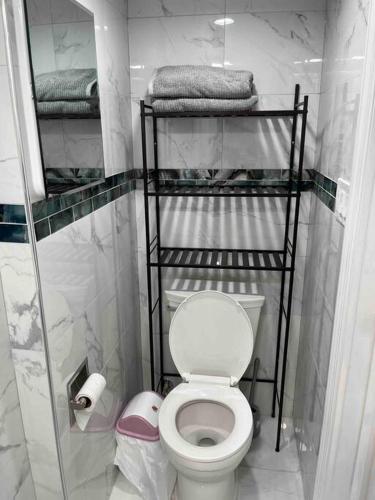 a small bathroom with a toilet and towels at 1 Bedroom Basement, NEWLY Renovated in Bellerose Terrace