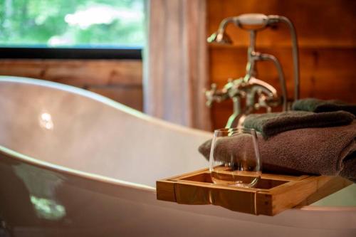 Una bañera con un vaso sobre una bandeja de madera. en Relaxing Escape, en Pigeon Forge