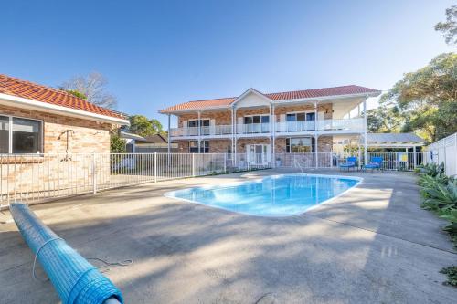 a house with a swimming pool in the yard at Pet friendly 24 Irawari Crescent - pool, air con, boat parking in Nelson Bay