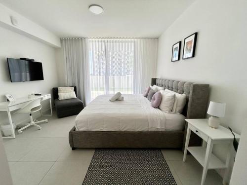 a bedroom with a bed and a desk and a computer at Comfortable Studio suites in downtown Doral in Miami