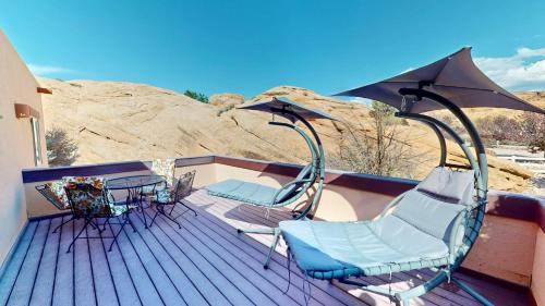 a deck with chairs and a table and an umbrella at The Rock #3461 in Moab