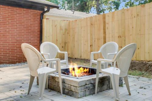 four chairs around a fire pit in a backyard at Charming 4-Bed Home with Modern Touches & Porch in Louisville