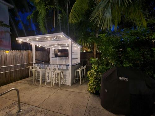 un patio con un bar con sillas y una parrilla en Duval Street Suite overlooking Duval w parking and pool, en Key West