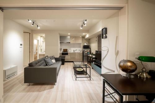 a living room with a couch and a table at Mondomio 207 in Sapporo