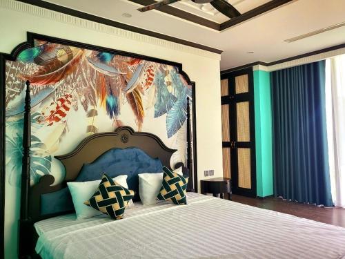 a bedroom with a large bed with a large headboard at Villa Flamingo Đại Lải in Ngọc Quang