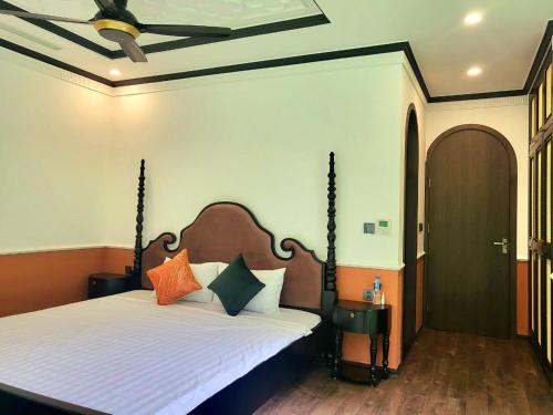 a bedroom with a bed with orange and black pillows at Villa Flamingo Đại Lải in Ngọc Quang