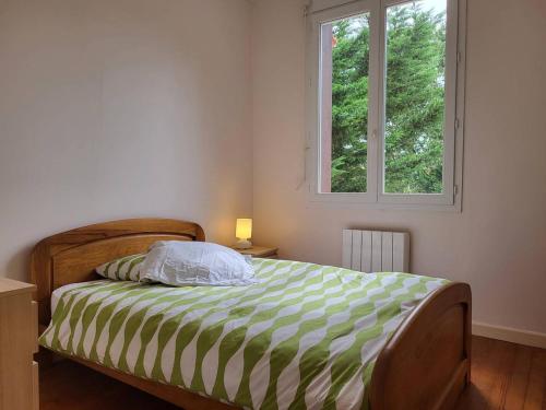 - une chambre avec un lit et une couette verte et blanche dans l'établissement Maison de famille avec jardin clos et terrasse proche de la plage - FR-1-788-31, à Merville-Franceville-Plage