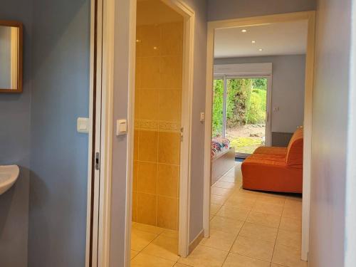 - un couloir avec une porte en verre menant à une chambre avec un canapé dans l'établissement Maison de famille avec jardin clos et terrasse proche de la plage - FR-1-788-31, à Merville-Franceville-Plage