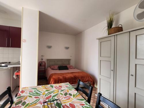 Cette chambre comprend un lit, une table et une cuisine. dans l'établissement Studio proche centre-ville et Thermes, WIFI, parking - FR-1-541-121, à La Roche-Posay