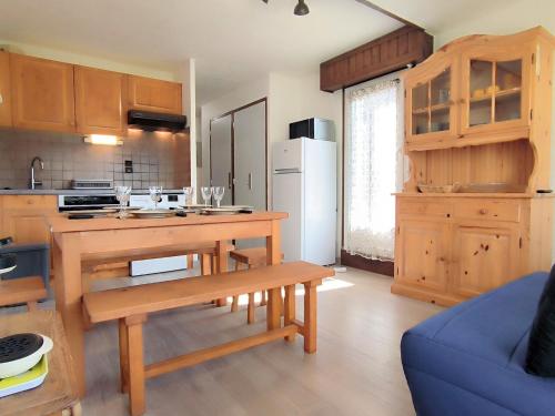 une cuisine avec des placards en bois et un canapé bleu dans l'établissement Appartement T3 à Samoëns avec terrasse et animaux acceptés - FR-1-624-161, à Samoëns