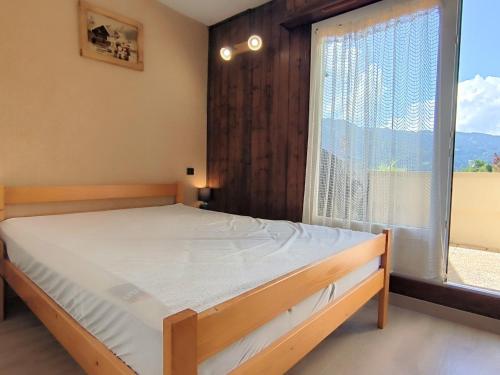 une chambre avec un lit et une grande fenêtre dans l'établissement Appartement T3 à Samoëns avec terrasse et animaux acceptés - FR-1-624-161, à Samoëns