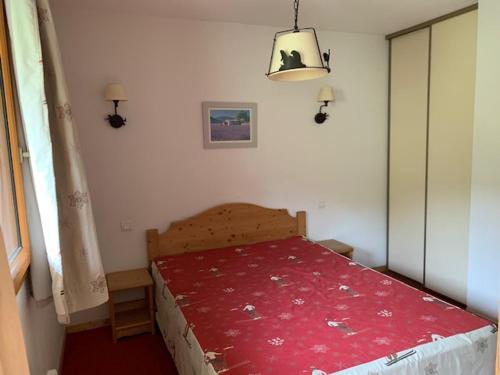 une chambre avec un lit avec une couverture rouge dans l'établissement Orcières Merlette: Appart 2 pièces, Parking, Piscine, WiFi - FR-1-636-232, à Orcières