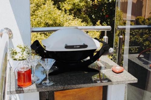 a grill on a table with glasses on a table at 185 on BEACH Boutique Suites in Gordonʼs Bay