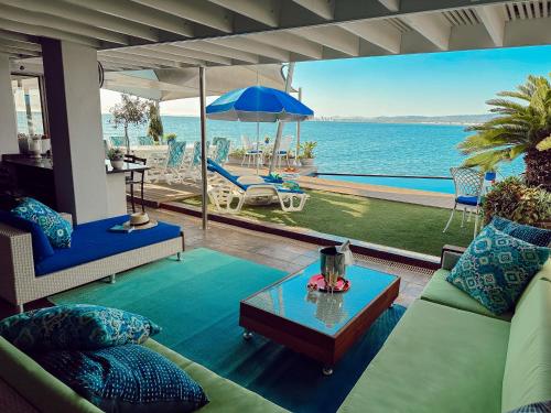 a living room with a view of the ocean at 185 on BEACH Boutique Suites in Gordonʼs Bay