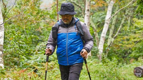 a man walking in the woods with poles at Tengu Onsen Asama Sanso in Komoro