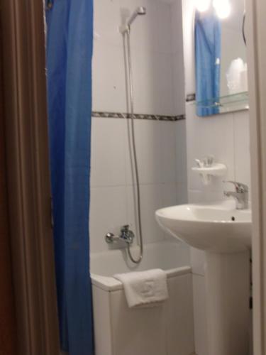 a bathroom with a sink and a shower with a shower curtain at Hostal La Torre in Santander