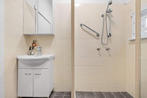 a white bathroom with a shower and a sink at Boutique Single Room - Centrally Located at Granville - Shared Bathroom in Sydney