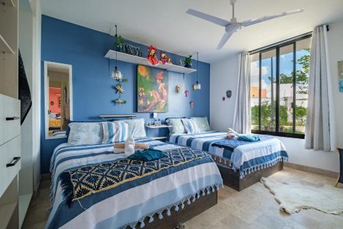 two beds in a room with blue walls at Casa Itzae La Luminaria Dog Friendly in San Miguel de Allende