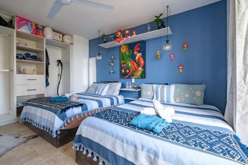 two beds in a room with blue walls at Casa Itzae La Luminaria Dog Friendly in San Miguel de Allende