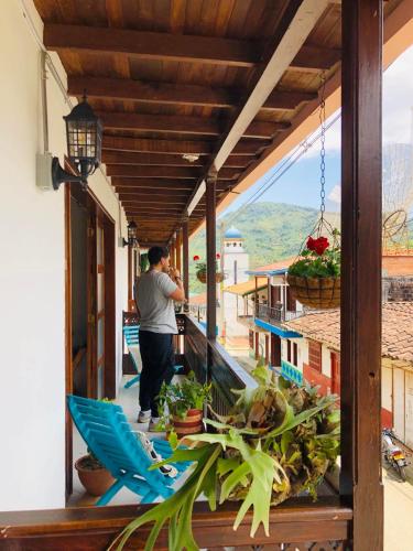 a man standing on the balcony of a house at HOTEL PLENITUD JARDÍN - Transporte, Tours y Más in Jardin