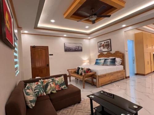 a living room with a bed and a couch at Spacious Seaview Studio in Lila, Bohol in Lila
