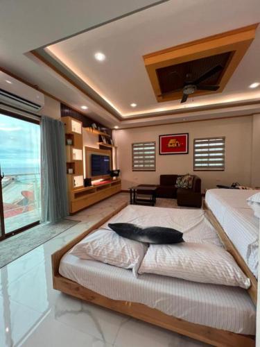 a bedroom with a large bed and a living room at Spacious Seaview Studio in Lila, Bohol in Lila