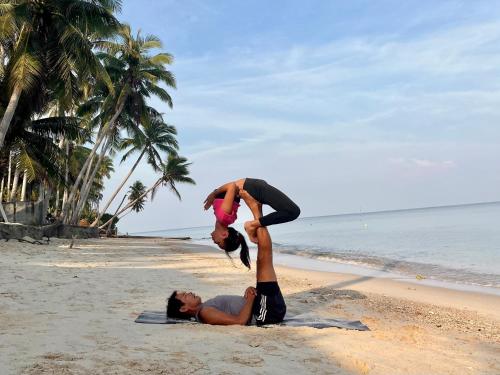 two people doing yoga on the beach at Moorea Boutique Resort Samui in Ban Tai