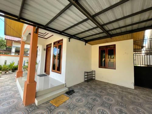 a house with awning and a porch with a patio at Mawar Homestay in Banda Aceh