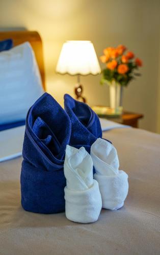a pair of shoes and towels on a bed at Laph Kham House in Chiang Mai