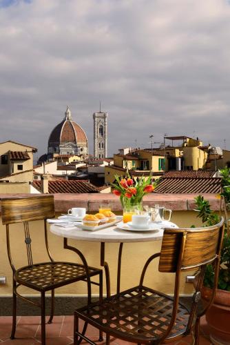 a table and chairs on a balcony with a view at Hotel L'Orologio Firenze - WTB Hotels in Florence