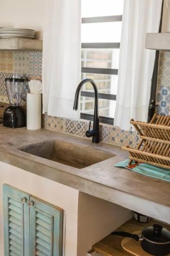 a kitchen counter with a sink and a window at Babylon Beach Villa 2 in San Pedro